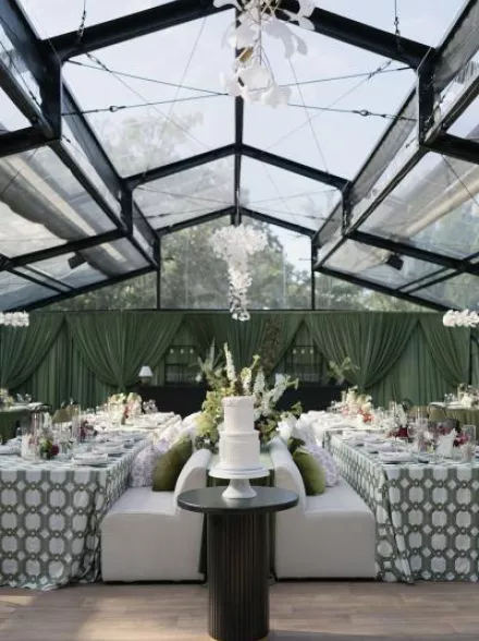 Bold maximalist reception design featuring luxe green draping and textured chandeliers at Woodland Glasshaus