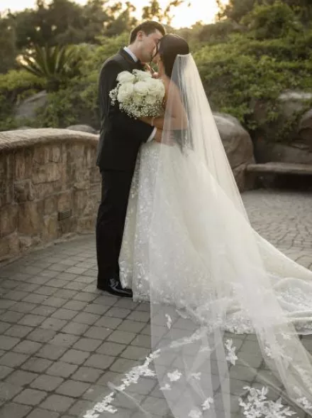 Bride and groom share a kiss during golden hour on grounds of Villa Loriana